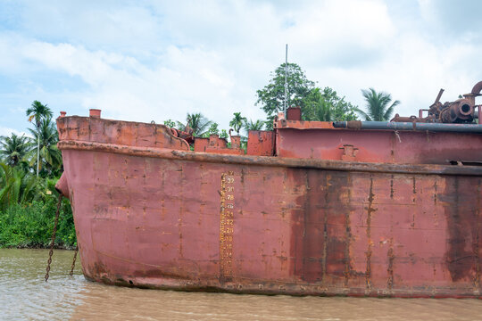 Coque d&rsquo;un vieux bateau rouill&eacute; sur une rivi&egrave;re tropicale