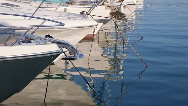Close-up of a yacht's bow with a folded anchor, rope tied to a cleat and teak deck, Port Hercule, Monaco