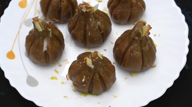Brown jaggery steamed modak presented in a white plate.