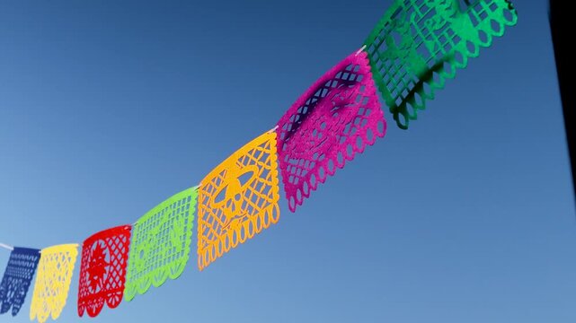 Colorful outdoor Day of the Dead papel picado banners fluttering in daylight