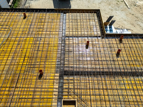 Drone view of the deployed steel mesh and yellow ceiling formwork. House construction. Construction of a single-family home. Structure. Construction. Preparing the reinforcement. Ceiling being poured.