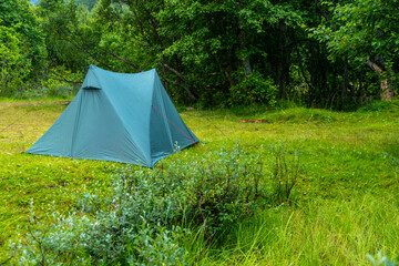 A beautiful green summer landscape with a tent near a river. A summer scenery of World Heritage Area in Western Norway. © dachux21