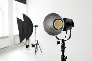 Professional LED studio light with reflector and softbox equipment in a bright photography studio © YarikL