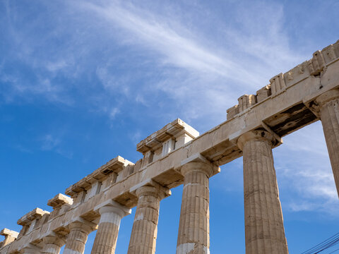 Perspective view of ancient Greek temple columns against blue sky