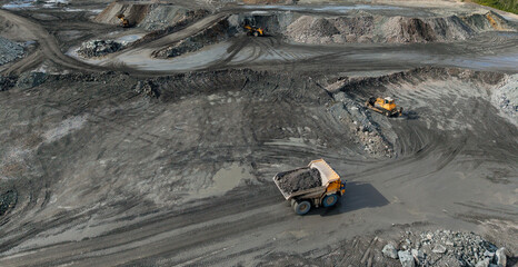 Obraz premium Open mining site with haul truck with gold and copper ore on road, Aerial view