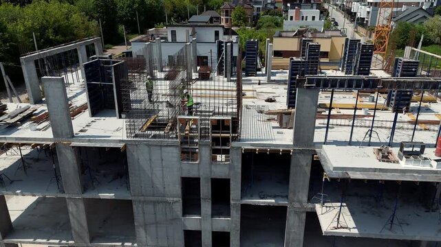 Aerial Drone view of workers and formwork on an unfinished residential building, Construction progress highlights concrete structures labor and urban growth