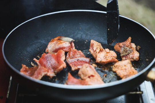 Wild Alaskan coho salmon cooking in a hot frying pan outside. Delicious seafood sizzling for a tasty snack.