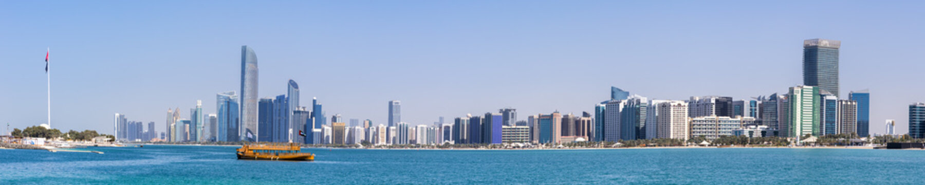 Abu Dhabi skyline with skyscrapers and Dhow boat banner panoramic view at sea in Abu Dhabi, United Arab Emirates