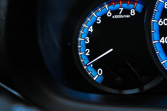 Car Tachometer Needle on Illuminated Dashboard
