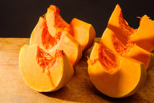pumpkin slice on wooden board. orange autumn vegetable. thanksgiving food ingredient. cut in to pieces