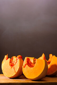pumpkin slice on wooden board. orange autumn vegetable. thanksgiving food ingredient. cut in to pieces
