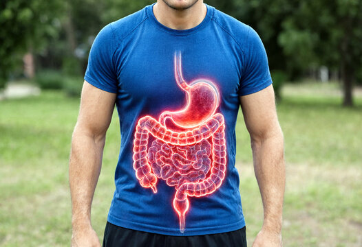 A man wearing a blue tshirt with a glowing illustration of the human digestive system including stomach and intestines visible through the fabric