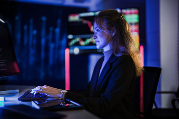 Businessman and businesswoman standing at a glowing AI brain wall behind desk monitors raise a...