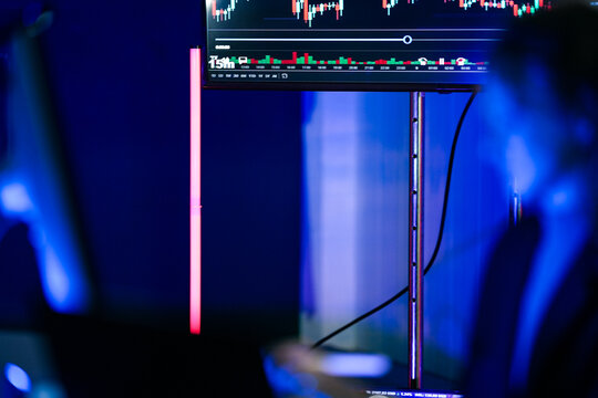 Young businesswoman with long fair hair working with a stylus at monitors of program code leans toward the monitor to inspect syntax as part of an executive briefing on digital