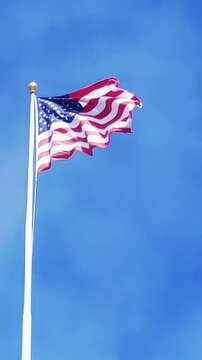 American flag waving on a pole blue sky