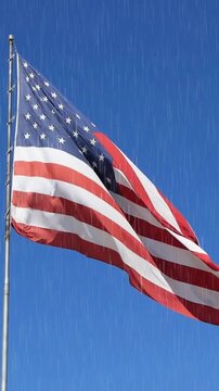 American flag waving against clear blue sky in rainy day