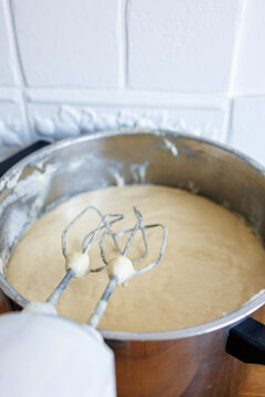 Electric hand mixer beating cake batter in mixing bowl