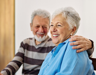Portrait of a happy senior couple embracing hugging and bonding at home
