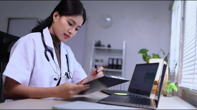 A female doctor in a white coat sitting at her desk, working and analyzing medical data, chemical structures, and graphs on dual laptops in a modern office or clinic setting.