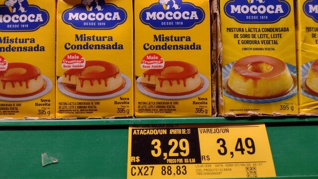 ITABIRA, MINAS GERAIS, BRAZIL - SEPTEMBER 03, 2026: Cartons of Mococa condensed milk substitute mixture featuring front-of-package high added sugar warning and zero lactose information, sold on grocer