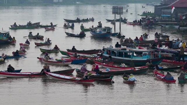 Traders sell fresh goods from wooden boats on the river at Lok Baintan Floating Market in Indonesia