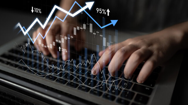 Close-up of hands typing on a laptop while financial charts display increasing and decreasing trends on the screen, emphasizing analysis and investment planning. Scalp