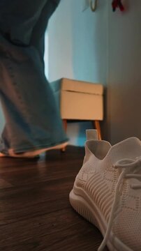 Woman entering an apartment and taking off her shoes 