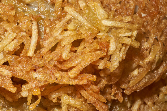 Close-up of homemade potato pancakes with a golden crispy crust and a texture of coarsely grated potatoes. Golden crispy potato pancakes made from freshly coarsely grated potatoes.