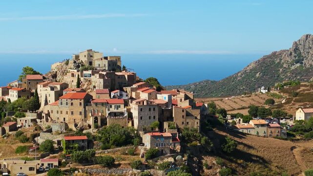 Aerial 70mm telephoto drone view of Sant Antonino perched medieval village in Corsica France. One of most beautiful mountain towns in Balagne 4K