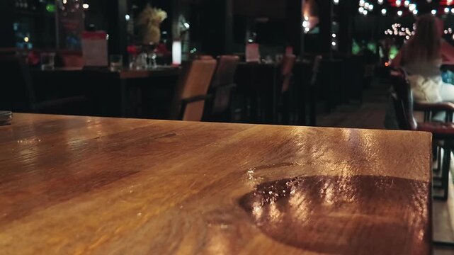 Man taking a partially empty glass from a bar counter
