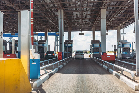 Toll road checkpoint, expressway entrance, highway payment booths with cars, transport infrastructure, traffic control, commuting, mobility and travel.