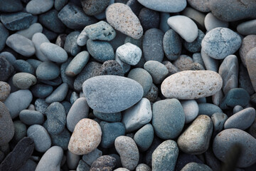 Obraz premium Sea pebbles background, smooth coastal stones texture in gray tones, natural pattern for beach, spa, wellness, geology, minimal design backdrop.