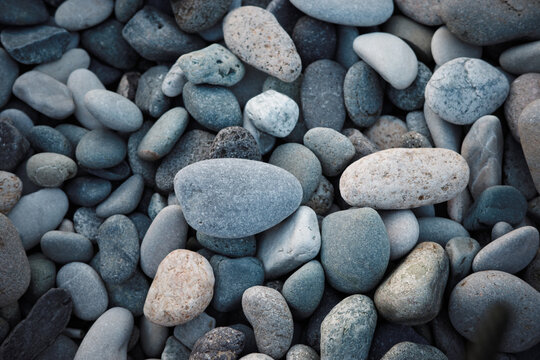 Sea pebbles background, smooth coastal stones texture in gray tones, natural pattern for beach, spa, wellness, geology, minimal design backdrop.