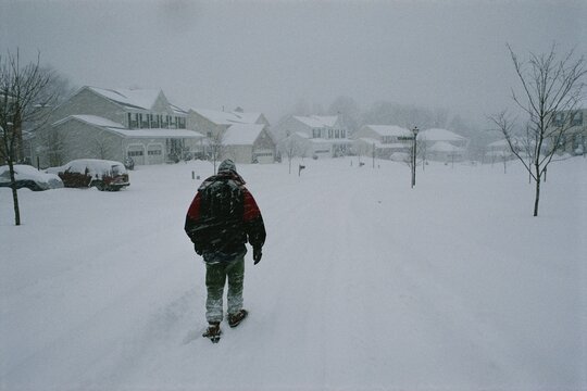 15 year-old american boy trudging through a heavy snowfall in a subdivision of the District of Columbia.