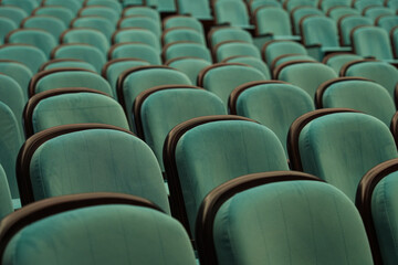 Obraz premium Empty turquoise theater chair awaiting audience