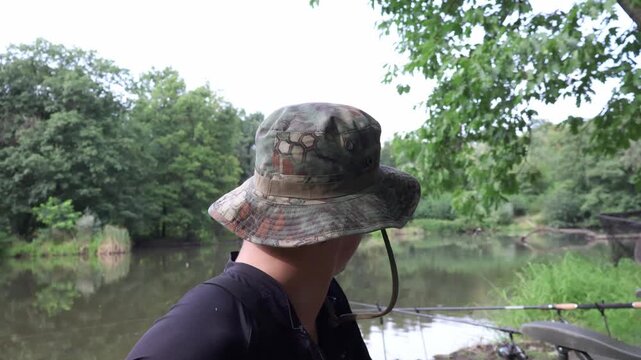 Angler recording fishing vlog. Fisherman talking to camera and observing nature while creating content.