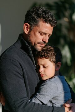 Father comforting son emotional indoor portrait and hug for parenting poster and mental health background