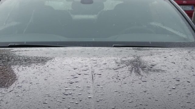 Close-up of rain on a car hood beneath the windshield and wipers, Cote d'Azur, France