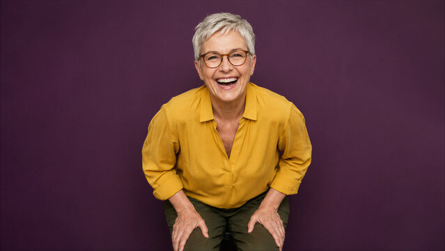 Senior woman leaning forward and laughing