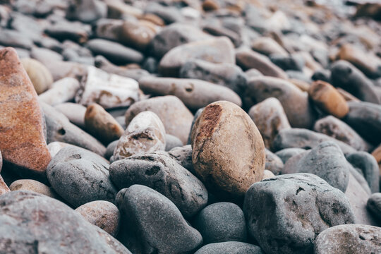 Close-up of smooth rounded stones covering a natural shoreline