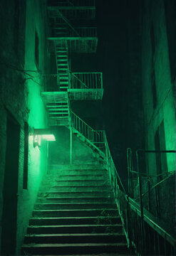 Exterior fire escape stairs glowing green at night Generative AI