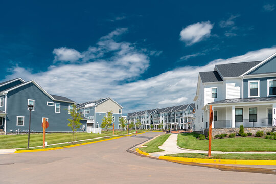 Modern townhomes line a curving suburban residential street in Leesburg, Virginia.