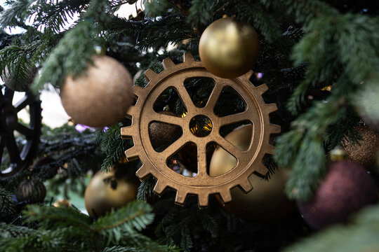 A steampunk Christmas decoration with golden gears and balls on the fir branches. New Year holiday.