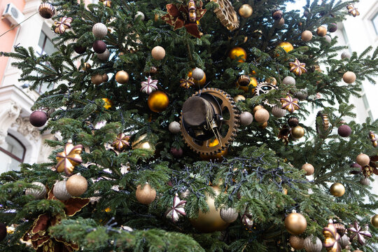 A steampunk Christmas decoration with golden gears and balls on the fir branches. New Year holiday.