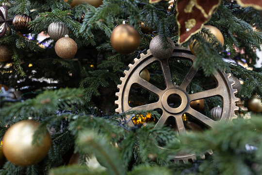 A steampunk Christmas decoration with golden gears and balls on the fir branches. New Year holiday.