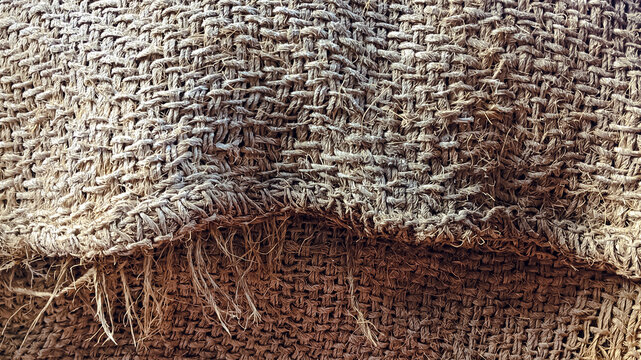 Burlap fabric texture background, natural jute textile with coarse weave and frayed edges, rustic brown eco material surface for design and packaging