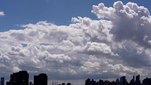 Stunning stock video of dramatic moving clouds rolling over a sprawling modern city skyline, perfect for weather, urban, and travel projects.
