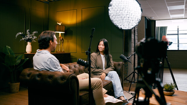 Content creators recording an interview for a podcast or talk show in a professional studio setting