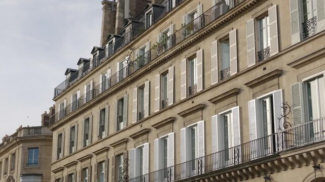 Historic Parisian apartment building with traditional windows, shutters, and balconies