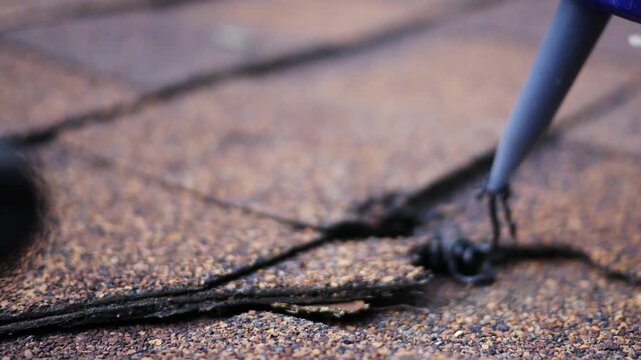  Man uses Caulk Gun to Insert Tar to repair roof
